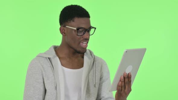 Video Chat on Tablet By African Man on Green Background