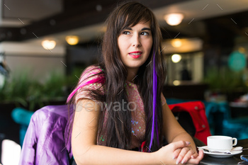 Young stylish trendy woman with multi-coloured strand in hair sits in cafe / Photodune, Misc