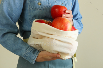 Woman holds bag with ripe red apples / Photodune, Misc