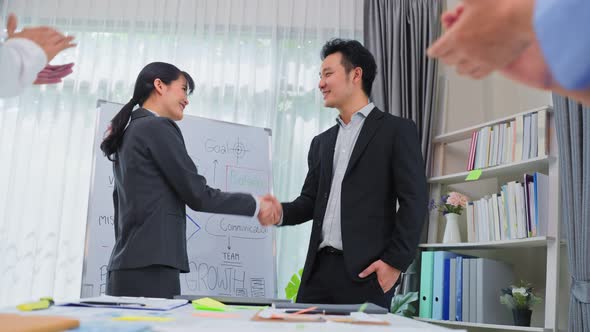 Asian businessman and woman handshake after negotiations for Business deal merger and acquisition.