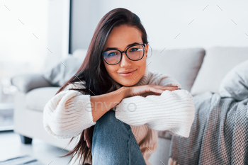 Young beautiful woman in casual clothes and in glasses sitting at home alone / Photodune, Misc
