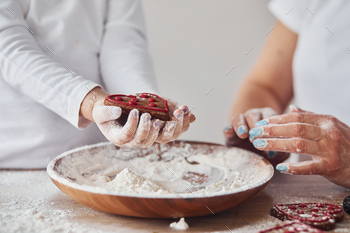 Close up view of woman with her granddaughter preparing food with flour on kitchen / Photodune, Misc