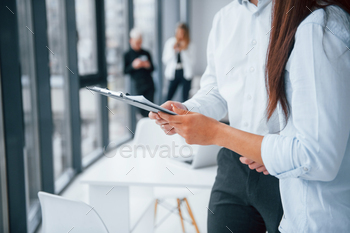 Woman and man talking about documents in front of young successful team / Photodune, Misc