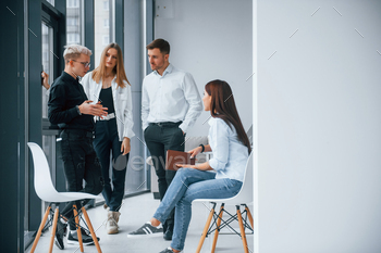 Group of young positive team have work and communicating together indoors in office near windows / Photodune, Misc