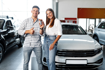 Young happy couple just bought a new car in a dealership / Photodune, Misc