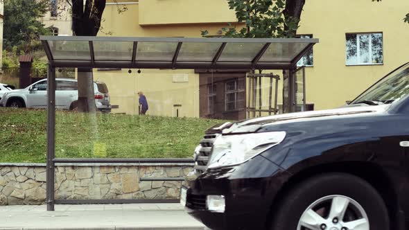 Two Boys Are Sitting At The Bus Stop.