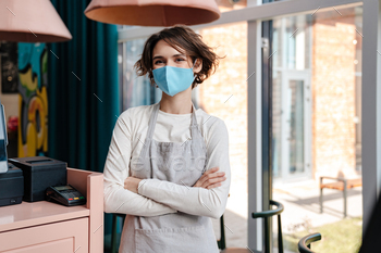 Young female worker with protective mask on face / Photodune, Misc