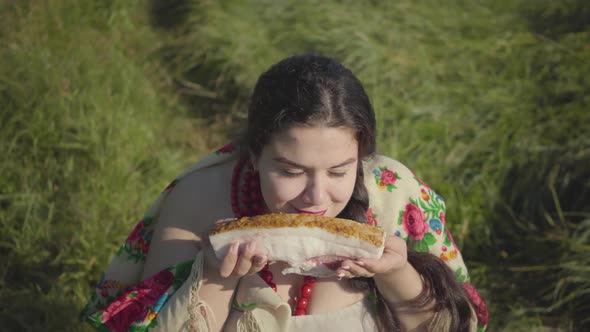 Portrait of Beautiful Overweight Woman Sitting in Grass Sniffing Tasty Lard Preparing To Eat