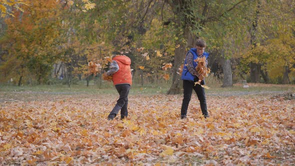 Boys Throw Fallen Autumn Leaves at Each Other.