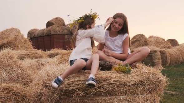 Girls Sitting on Hay