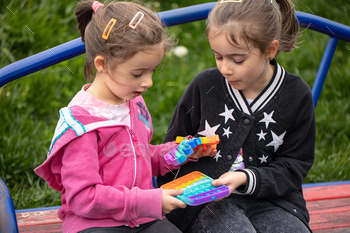 Little girls play with a colorful anti-stress toy pop it. / Photodune, Misc