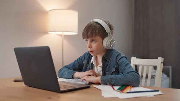 Homeschooling Online By Videocall Caucasian Teen Boy Sitting at Workplace in Living Room and Uses a