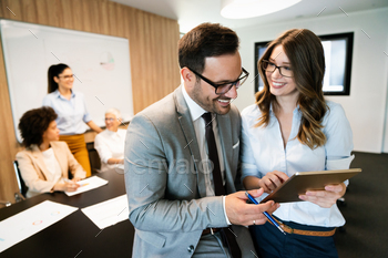 Happy business colleagues in modern office using tablet / Photodune, Misc