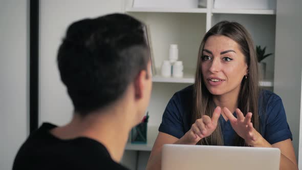 Man Comes Into the Therapist Office Consulting with Pretty Female Doctor for Healthcare