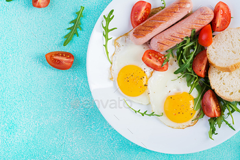 English breakfast - fried eggs, sausages, tomatoes and fresh arugula. / Photodune, Misc