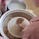 Female Potter Sitting and Makes a Cup on the Pottery Wheel. Woman Making Ceramic Item. Pottery - VideoHive Item for Sale