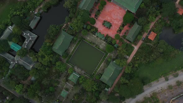 aerial top down clockwise rotation of ancient Buddhist temple and gardens in south Vietnam