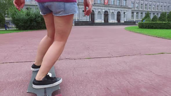 Close low angle view of women legs riding on a longboarding