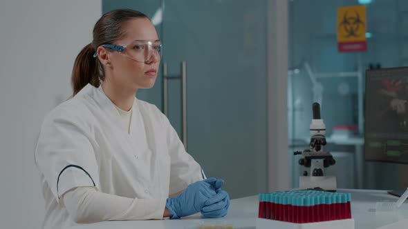 Woman Chemist Wearing Virtual Reality Goggles in Science Laboratory