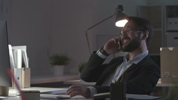Businessman Making Phone Call in  Night Office
