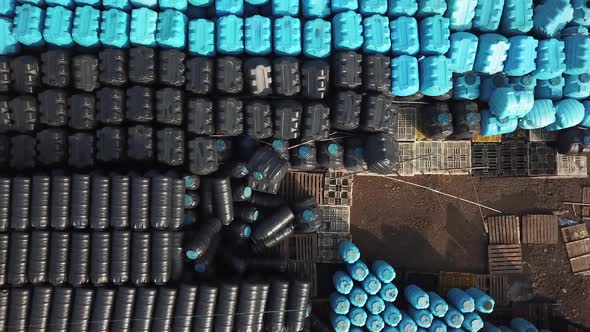 Aerial View of Blue and Black Plastics Barrels Tanks Open-air Warehouse