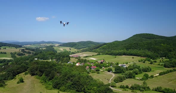 Quadrocopter in Flight Over Rural Landscape in 4K