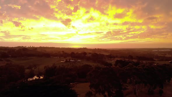 Aerial shot of the last remaining glow of the setting sun over farmland in rural Australia.