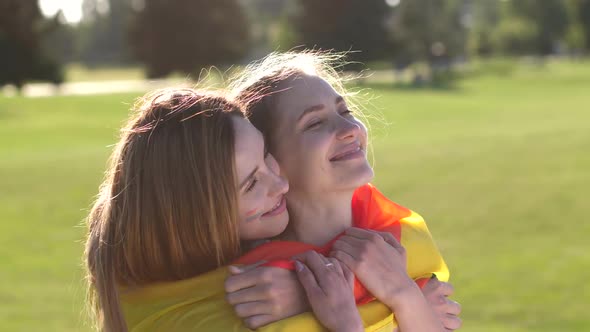 Portrait of Joyful Lesbian Couple Cuddling in Park