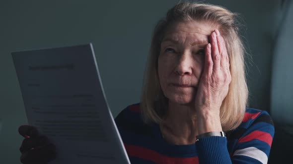 Worried Elderly Woman Reading Doctor Report