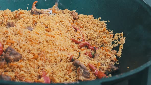 Big Vat with Cooked Pilaf or Rice Over an Open Fire. Street Food at the Party