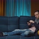 Cheerful Middle Aged Man Sitting on the Sofa Using Phone Modern Apartment Texting Message Scrolling - VideoHive Item for Sale