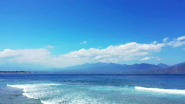 Natural flying tourism shot of a white sand paradise beach and blue ocean background in colourful