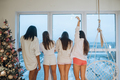 Young women in pajamas standing at the huge window - PhotoDune Item for Sale
