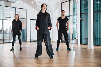Trainer with students meditating in standing position / Photodune, Misc