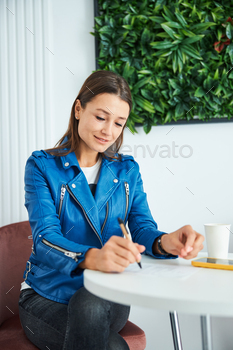 -point pen in one hand sitting cross-legged at the table in a wellness center
