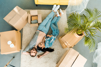 top view of couple lying on floor and relaxing after packing for new house, moving concept / Photodune, Misc