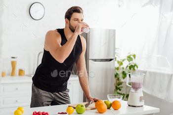 bearded man drinking fresh smoothie near blender and fruits / Photodune, Misc
