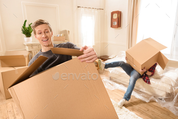 Young friends with cardboard boxes moving into new house / Photodune, Misc