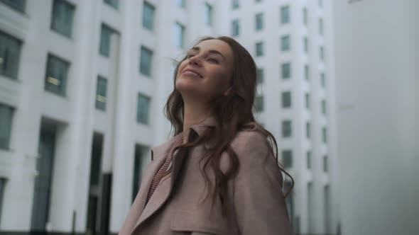 Portrait of a beautiful woman walking along the city street. Business girl close-up smiling