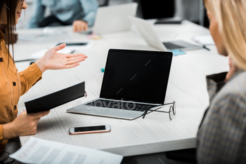 partial view of businesswomen working on project together at workplace with laptop in office / Photodune, Misc