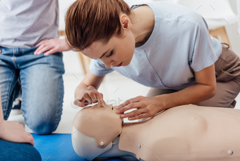 woman practicing cpr technique on dummy during first aid training / Photodune, Misc