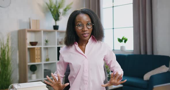 Woman in Glasses which Sitting at the Table in Home Studio and Talking with Audience