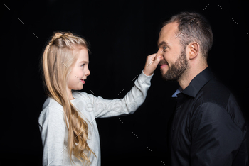Smiling father and daughter having fun together isolated on black / Photodune, Misc