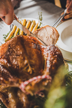 Close up partial view of man carving roasted turkey at table served for Christmas / Photodune, Misc