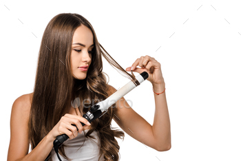 beautiful girl with long brown hair using curling iron isolated on white / Photodune, Misc