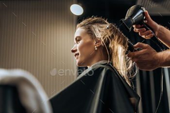 cropped shot of hairstylist drying hair to smiling girl in beauty salon / Photodune, Misc