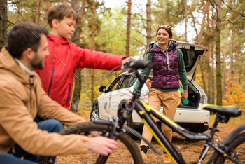 Happy family with bicycle in autumn forest with white car / Photodune, Misc