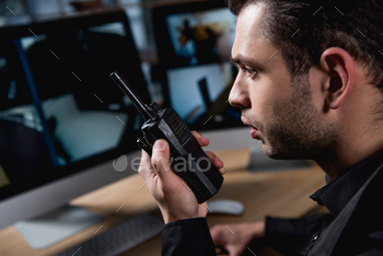 selective focus of guard holding walkie-talkie at workspace / Photodune, Misc