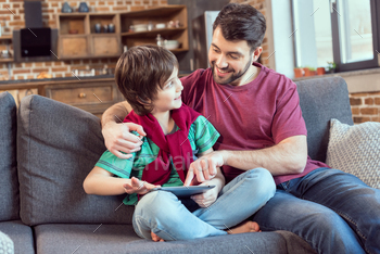 cheerful father and son using digital tablet at home / Photodune, Misc