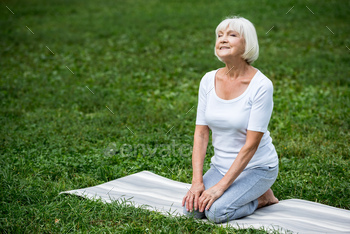 happy senior woman sitting in meditation pose with hands on knees and closed eyes / Photodune, Misc
